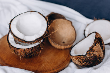 Fototapeta na wymiar Coconuts. Ripe coconuts lie on a wooden tray. Organic product. Broken coconut. Composition of coconuts.