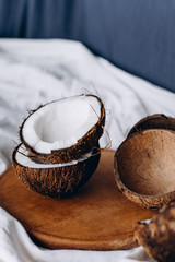 Coconuts. Ripe coconuts lie on a wooden tray. Organic product. Broken coconut. Composition of coconuts.