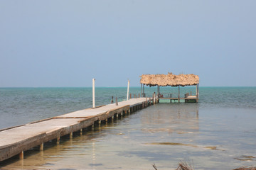 old wooden pier with tropical hut on the beach