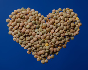 Heart shaped lentils on a dark blue background. Healthly food. I love lentils concept.