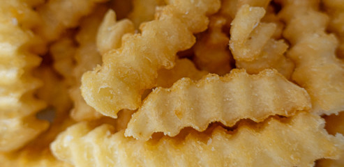 Crispy, crunchy, salty goodness french fries cut from golden potatoes, top and wide close up view.