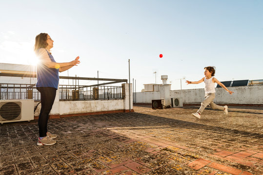 A Woman And A Child Playing Ball.