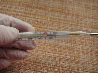The thermometer shows the normal body temperature. 36.7 degrees Celsius.  The thermometer is held...