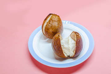 Baked pear with cottage cheese filling on white plate. Light healthy dessert without sugar on pink background. Mellow pears lenten dessert with curd
