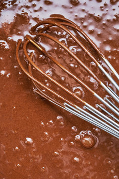 Chocolate batter in a pot with whisk