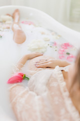 Obraz na płótnie Canvas pregnant woman in a bath with flowers