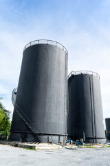 Black fuel tank And large During the day time, the sky is blue and cloudy.