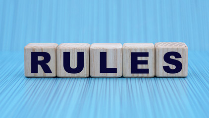 the concept of the word RULES on cubes on a blue background in a stripe