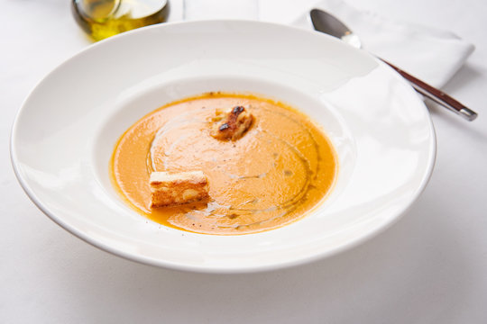 Delicious creamy carrot soup with croutons and olive oil