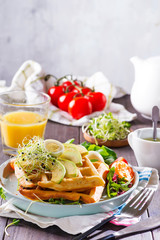 Breakfast time. Waffle with salad, egg, juice and avocados for breakfast.