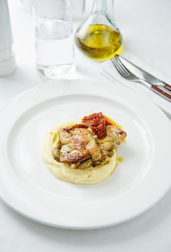 Dish of roasted chicken with herbs and salsa over potato puree