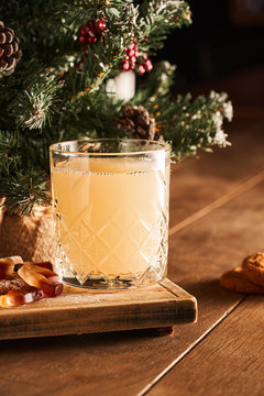 Hot mulled white wine cocktail served in a glass on wooden board