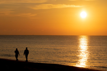 Obraz premium silhouette of a couple walking on the beach
