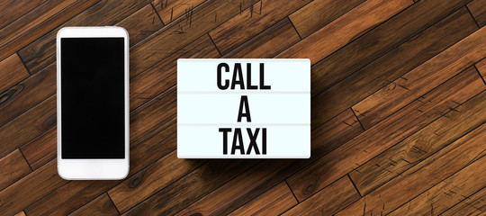 lightbox with text CALL A TAXI on wooden background
