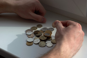 A man counts money and divides it. Round coins. 