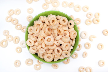 healthy cereal rings on a white background in a plate and scattered on the table. morning eat. Healthy breakfast. Dry muesli.