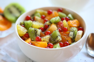 Healthy summer Breakfast concept, fruit salad in  a white bowl. Vegetarian food concept. Weight loss concept.