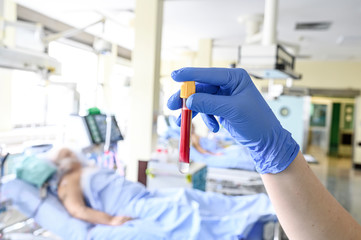 Blood sample test tube in hands of intensive care unit nurse. Corona virus outbrake image.