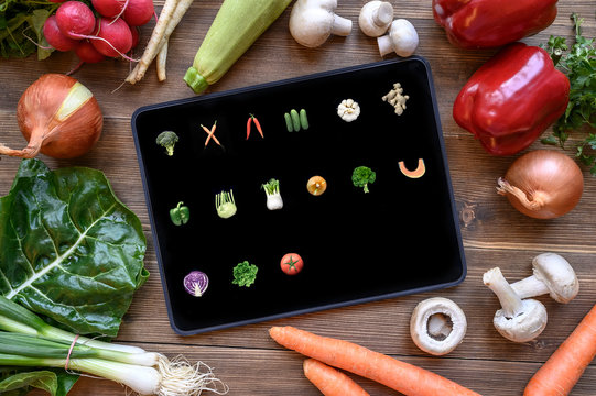 Vegetable icons on black pad screen. Concept image of  fresh vegetarian food and computer tablet.