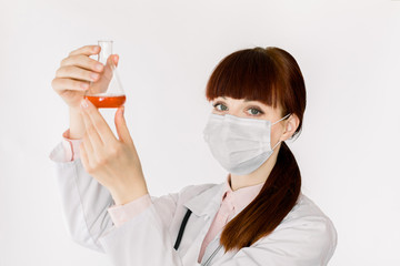 Portrait of beautiful young female laboratory assistant, scientific researcher or doctor holding flask with red liquid, new substance or medicine. Science, healthcare concept. Isolated over white.