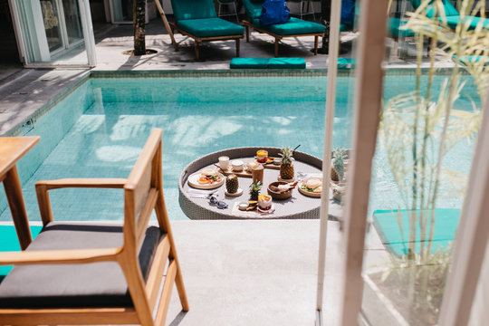 Photo of exotic fruit lunch at hotel. Picture of table in pool with coffee and sweets.