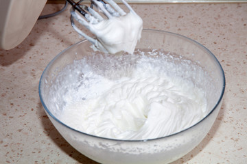 making whipped cream with a mixer in the kitchen