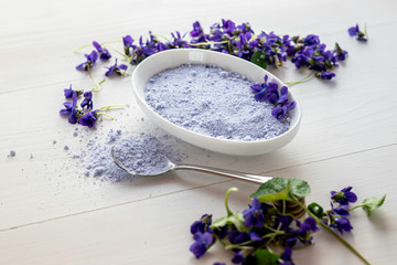 Fototapeta na wymiar viola violeta odorata violet natural sugar bath salt on white background in porcelain dish