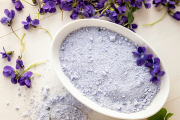 Fototapeta na wymiar viola violeta odorata violet natural sugar bath salt on white background in porcelain dish 