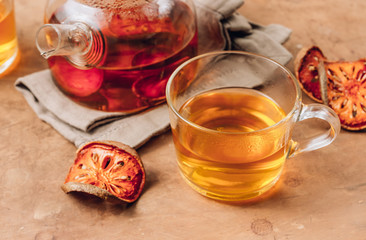 Bael fruit juice or quince tea and dried bael sliced fruit on rustic background. Thai or Asian healthy drink. Bael is helping the body to resist catching a cold.