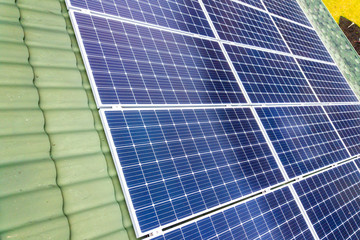 Obraz premium Aerial top view of new modern residential house cottage with blue shiny solar photo voltaic panels system on roof. Renewable ecological green energy production concept.