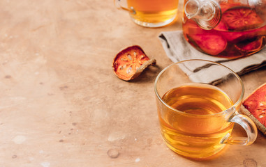 Bael fruit juice or quince tea and dried bael sliced fruit on rustic background. Thai or Asian healthy drink. Bael is helping the body to resist catching a cold.