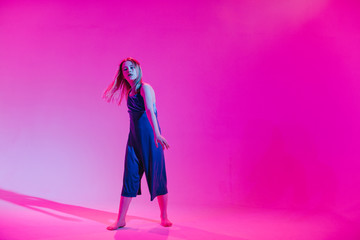 Young stylish girl dancing in the Studio on a colored neon background. Music dj poster design.