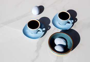 Obraz na płótnie Canvas cups of tea and blue eggs with a white background