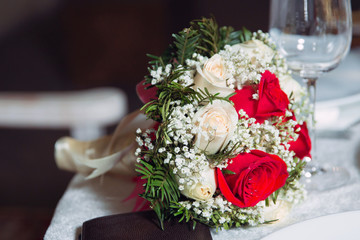 Wedding bouquet of white roses on a white and red table. top view . Beautiful wedding bouquet of white and red roses.