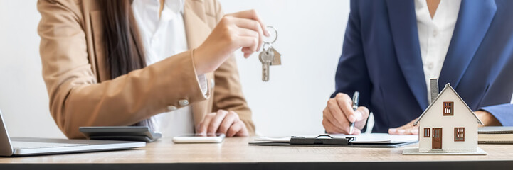 Real estate agent holding a key and asking costumer for contract to buy, get insurance or loan real...