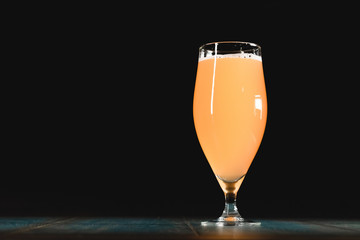 Poured beer on a dark background on a wooden table. The concept of relaxation and pastime