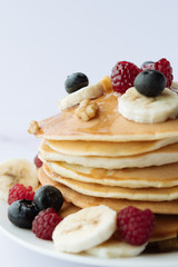 breakfast, pancakes with raspberry, blueberry, nuts, banana and honey