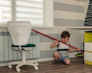 Little boy cleans his room, mops floors