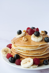 breakfast, pancakes with raspberry, blueberry, nuts, banana and honey
