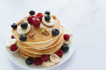 breakfast, pancakes with raspberry, blueberry, nuts, banana and honey
