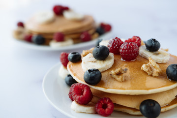 breakfast, pancakes with raspberry, blueberry, nuts, banana and honey