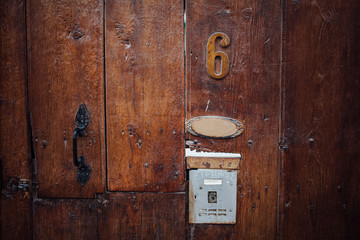 old wooden door with bell and number 