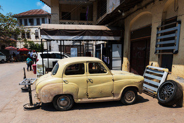 old rusty car in the street of stone town zanzibar - obrazy, fototapety, plakaty