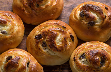 Homemade buns with raisins and cottage cheese on wooden background