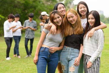 Fototapeta premium Happy young group of friends hanging out together at the park