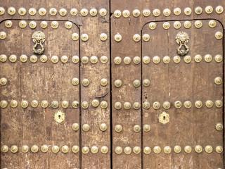 Puerta de madera antigua con remaches de metal dorados
