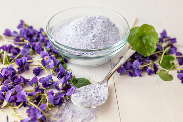 Obraz na płótnie Canvas close up lilac sweet sugar crystals bath salts from fresh viola violet violetta odorata blossom flowers 