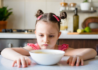 Little Girl doesn’t want to eat vegetable puree soup. Healthly food. Vegetarian soup