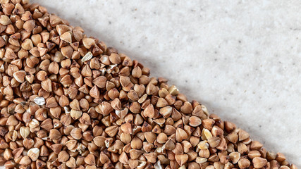 Essential goods: Buckwheat. Buckwheat seed pour in bunch closeup. Buckwheat cereal background.