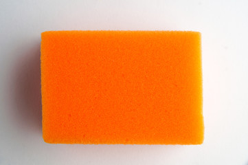 orange foam sponge for utensils on a white background